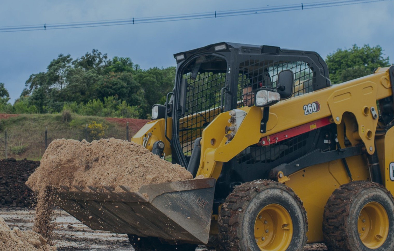 Construcción – minicargador (banner) Minicargador trabajando con material